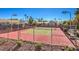 Well maintained tennis court surrounded by a fence with manicured landscaping and mature palm trees in the background at 2761 Carnation Ln # 1, Henderson, NV 89074
