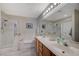 Bathroom featuring double sinks, wood cabinets, a shower, and a soaking tub at 2925 Wigwam Pkwy # 123, Henderson, NV 89074