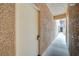 Hallway leading to unit's front door in a tan building with desert landscaping at 2925 Wigwam Pkwy # 123, Henderson, NV 89074