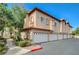 Two-story townhome featuring attached garages, landscaping, and a tile roof at 2925 Wigwam Pkwy # 123, Henderson, NV 89074