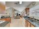 Open concept kitchen with granite countertops, stainless steel appliances, and tile flooring that flows to the living room at 2925 Wigwam Pkwy # 123, Henderson, NV 89074