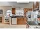 Well-lit kitchen featuring wood cabinetry, granite countertops, and stainless steel appliances, with a fireplace nearby at 2925 Wigwam Pkwy # 123, Henderson, NV 89074