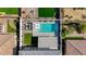 Aerial view of a fenced backyard with a pool, patio furniture, and green spaces, offering privacy and comfort at 2940 Duverney Ave, Henderson, NV 89044
