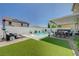 Spacious backyard featuring a sparkling pool, outdoor kitchen, covered patio, and lush landscaping at 2940 Duverney Ave, Henderson, NV 89044