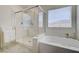 Bright bathroom featuring a glass enclosed shower and soaking tub with gold hardware at 2940 Duverney Ave, Henderson, NV 89044