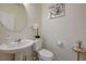 Well-lit half bathroom with a pedestal sink, modern fixtures, and decorative accents at 2940 Duverney Ave, Henderson, NV 89044