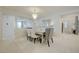 Elegant dining area featuring a modern chandelier, mirrored table, and bright, tiled flooring at 2940 Duverney Ave, Henderson, NV 89044