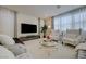 Bright living room featuring a large TV, stylish armchairs, and floor-to-ceiling windows at 2940 Duverney Ave, Henderson, NV 89044