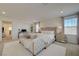 Bright primary bedroom showcasing a large bed, a small desk, and neutral decor at 2940 Duverney Ave, Henderson, NV 89044