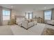 Spacious primary bedroom with a tufted headboard bed, sitting area, and abundant natural light at 2940 Duverney Ave, Henderson, NV 89044