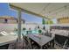 Charming covered patio with outdoor dining and seating areas overlooking a sparkling pool and lush backyard at 2940 Duverney Ave, Henderson, NV 89044