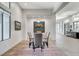 Modern dining area featuring wood look floors and a contemporary chandelier and large windows at 33 Hassayampa Trl, Henderson, NV 89052