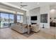 Cozy living room featuring modern fireplace, neutral tones, and large sliding glass doors leading to outdoor patio at 33 Hassayampa Trl, Henderson, NV 89052