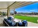 Covered outdoor patio area with comfortable seating and views of the green backyard at 33 Hassayampa Trl, Henderson, NV 89052