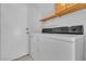 Laundry area featuring a stacked washer and dryer, overhead cabinet, and shelving at 3544 Mountain Valley Dr, Las Vegas, NV 89129