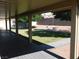 Covered patio overlooking manicured backyard with a rock perimeter, a fire pit and mature trees for shade at 391 Newbury Ct, Henderson, NV 89015