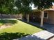 Lush backyard with manicured lawn, covered patio with furniture, and low maintenance landscaping at 391 Newbury Ct, Henderson, NV 89015
