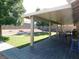 Covered backyard patio with deck, dining set and seating overlooking green lawn and rock landscape at 391 Newbury Ct, Henderson, NV 89015