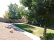 Mature landscaping frames the backyard, with grass and shade trees visible from the covered patio at 391 Newbury Ct, Henderson, NV 89015