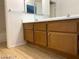 Bathroom vanity with wood cabinets, double sinks, mirror, and tile flooring at 4021 Broadriver Dr, Las Vegas, NV 89108
