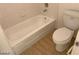 Bathroom featuring a white toilet, tub with tile surround, and tile flooring at 4021 Broadriver Dr, Las Vegas, NV 89108