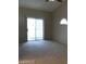Carpeted bedroom with a sliding glass door leading to the patio and large windows at 4021 Broadriver Dr, Las Vegas, NV 89108
