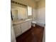 Bathroom features a large mirror, single sink vanity, shower over tub and wood look flooring at 416 Richgold St, Henderson, NV 89012
