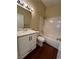 Bathroom features a single sink vanity with storage, a shower over tub and wood look flooring at 416 Richgold St, Henderson, NV 89012