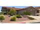 A well-landscaped front yard with mature trees, bushes, and rocks adding character to the property at 416 Richgold St, Henderson, NV 89012