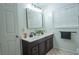 Well-lit bathroom with a double vanity, dark cabinets, and a modern mirror at 4161 Royalhill Ave, Las Vegas, NV 89121