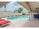 Backyard pool surrounded by lounge chairs and green landscaping, ideal for relaxation and outdoor entertainment at 4161 Royalhill Ave, Las Vegas, NV 89121