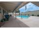 Spacious backyard featuring a sparkling pool, covered patio, and comfortable seating areas at 4161 Royalhill Ave, Las Vegas, NV 89121
