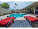 Relaxing backyard pool area with lounge chairs, outdoor seating and mature landscaping at 4161 Royalhill Ave, Las Vegas, NV 89121