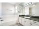 Bright bathroom features tub with white tile surround and granite countertop vanity at 4657 Curdsen Way, Las Vegas, NV 89110