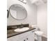 Bathroom featuring a granite countertop, vanity with dark hardware, round mirror, and toilet at 4657 Curdsen Way, Las Vegas, NV 89110