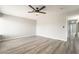 Spacious bedroom featuring gray wood-look flooring, ceiling fan and neutral wall color at 4657 Curdsen Way, Las Vegas, NV 89110