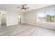 Well-lit bedroom with gray wood-look floors, a ceiling fan, and an exterior view from the window at 4657 Curdsen Way, Las Vegas, NV 89110