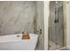 Luxurious bathroom features a soaking tub, separate shower, and elegant tile work with gold accents at 4774 Walteta Way, Las Vegas, NV 89119