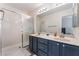 Bathroom featuring double sink vanity and walk-in shower with glass doors at 4909 Desert Poppy Dr, Las Vegas, NV 89130