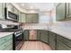 Modern kitchen features stainless steel appliances, ample countertop space, and stylish green cabinetry at 4909 Desert Poppy Dr, Las Vegas, NV 89130