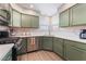 Well-appointed kitchen with stainless steel appliances, green cabinetry, and a bright, airy atmosphere at 4909 Desert Poppy Dr, Las Vegas, NV 89130