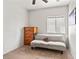 A simple bedroom furnished with a futon and dresser, lit by natural light at 4916 White Jade St, North Las Vegas, NV 89081