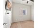Simple bedroom with neutral walls and carpet, featuring a mounted TV and natural light at 4916 White Jade St, North Las Vegas, NV 89081
