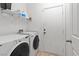 Bright laundry room with shelving, a washer and dryer, and a door leading outside at 4916 White Jade St, North Las Vegas, NV 89081