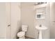 Small bathroom with modern toilet, pedestal sink, and vanity lighting at 5021 Ropers Rock Ct, Las Vegas, NV 89131