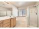 Bright bathroom with double vanity, large soaking tub, and glass-enclosed shower at 5021 Ropers Rock Ct, Las Vegas, NV 89131