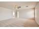Large bedroom with ceiling fan, neutral carpet, and hallway entrance at 5021 Ropers Rock Ct, Las Vegas, NV 89131