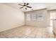 Open living room with ceiling fan, backyard access, and three large windows at 5021 Ropers Rock Ct, Las Vegas, NV 89131