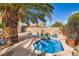 Inviting pool area with a rock waterfall feature, lush landscaping, and a large shade tree at 5021 Ropers Rock Ct, Las Vegas, NV 89131