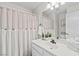 Well-lit bathroom showcasing a vanity with sink and a shower with a stylish curtain at 5108 Molveno Ct, Las Vegas, NV 89130